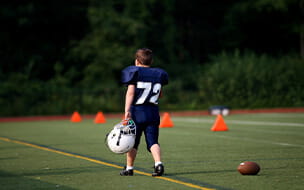 Young football player participates in a youth football season, capturing a momentson the field along the sidelines