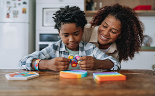 Mother playing with autistic son at kitchen table