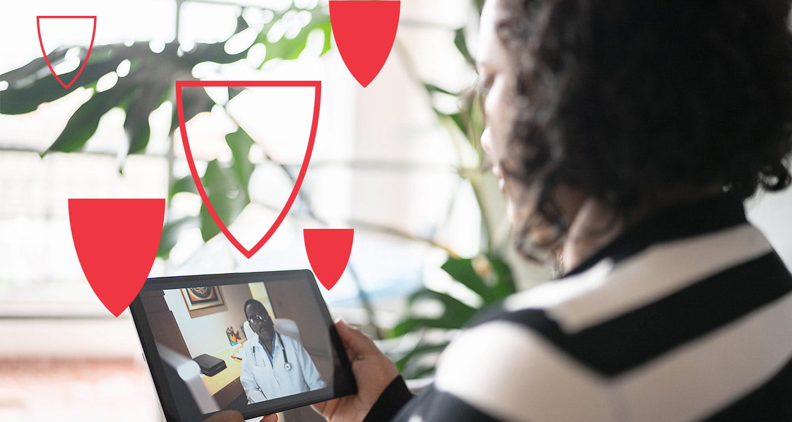 An adult woman on a video call with a doctor on the digital tablet at home
