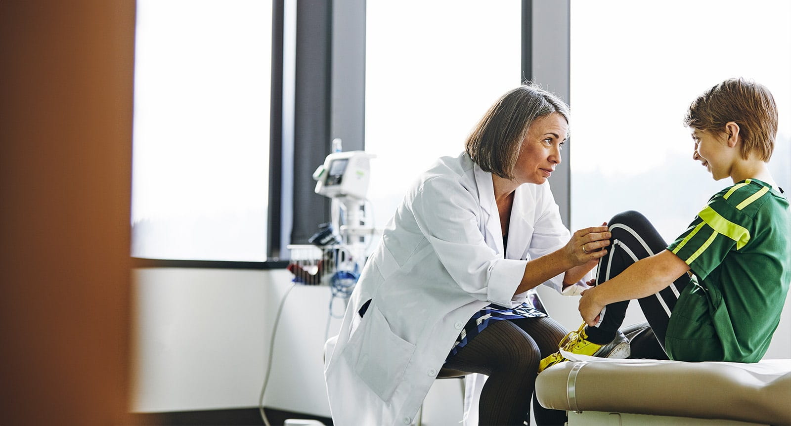 A female doctor examines a young boy during a primary care checkup
