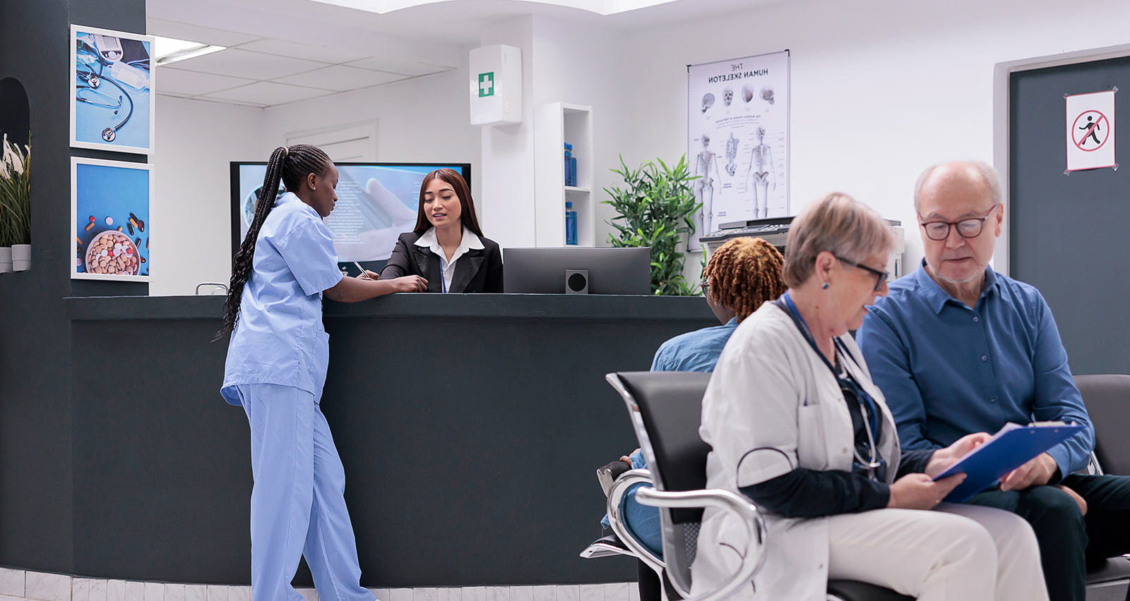 A nurse and receptionist doing registration work in hospital waiting room