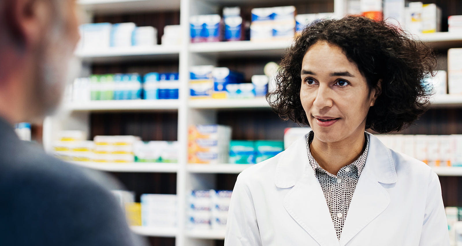 A pharmacist serving her patient by filling a prescription