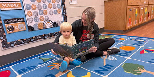 A woman reads to a toddler at the Child Care Center at UH Parma Medical Center