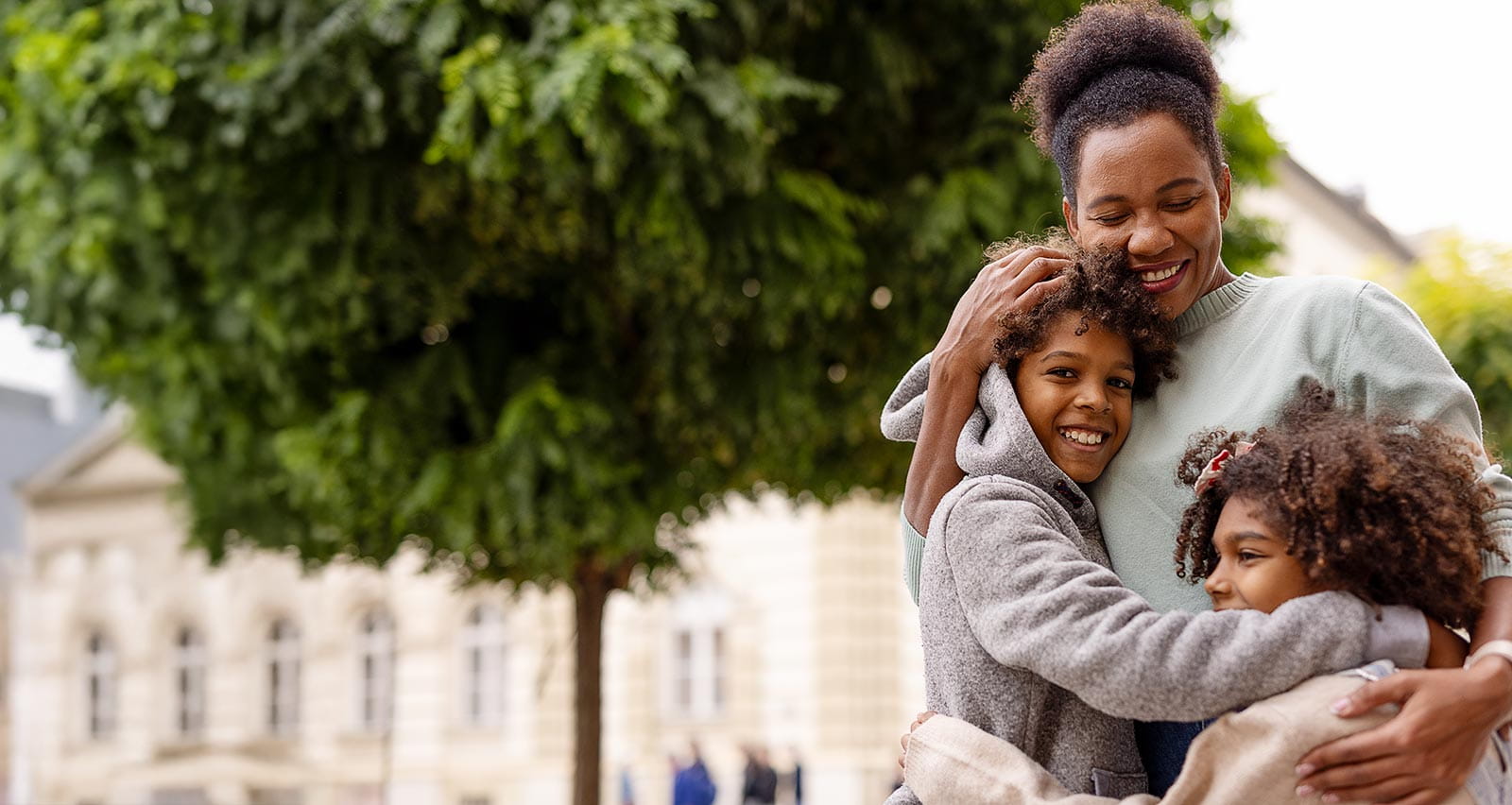 A single mother, son and daughter hugging and smiling