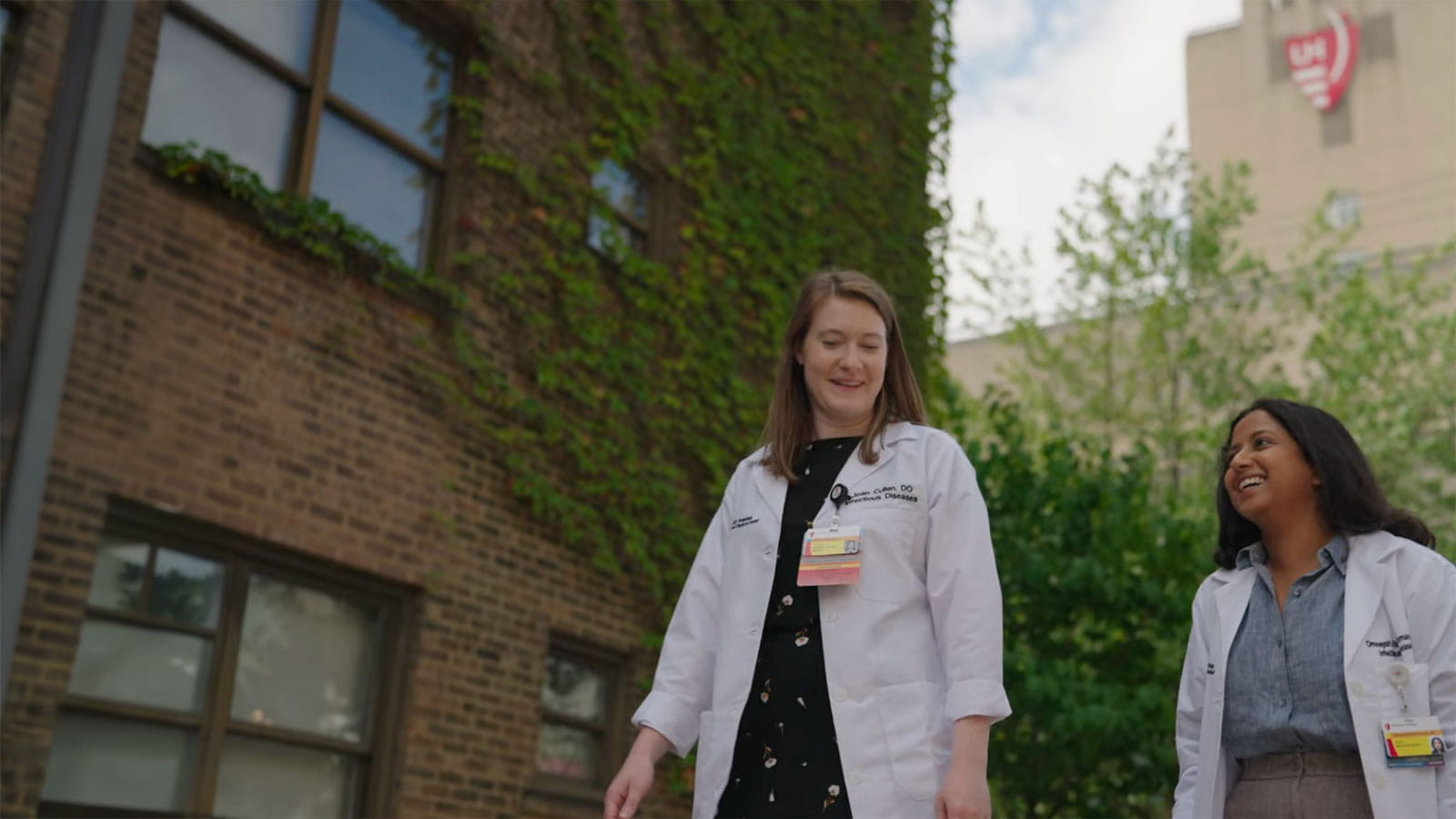 physician and fellow walking by UH tower