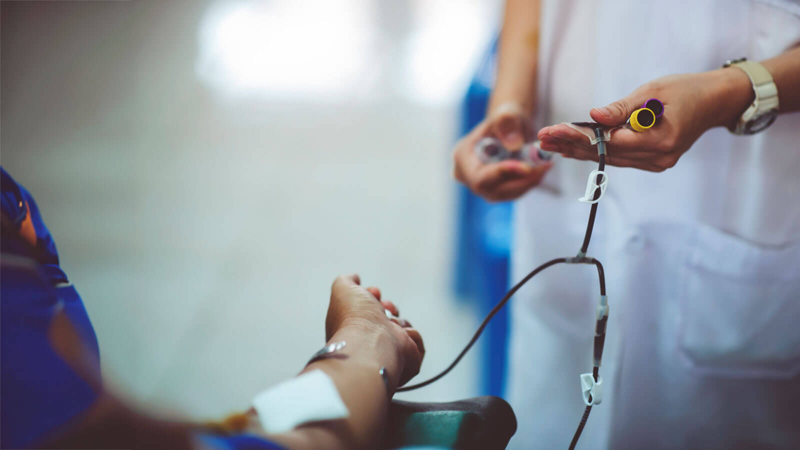 physician assisting patient with a blood transfusion 