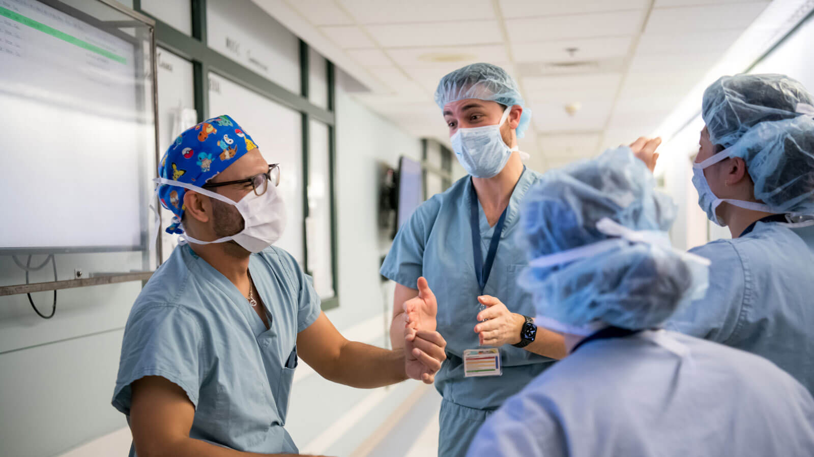physician talking with fellows in scrubs