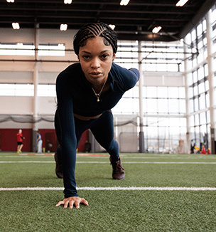 Thumbnail image of a female athlete doing a one-handed push-up.