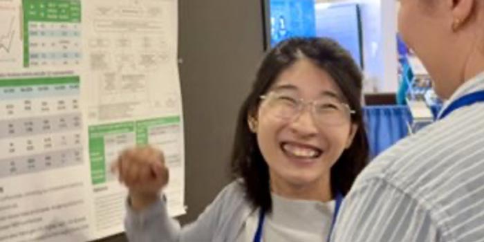 fellows explaining her research poster