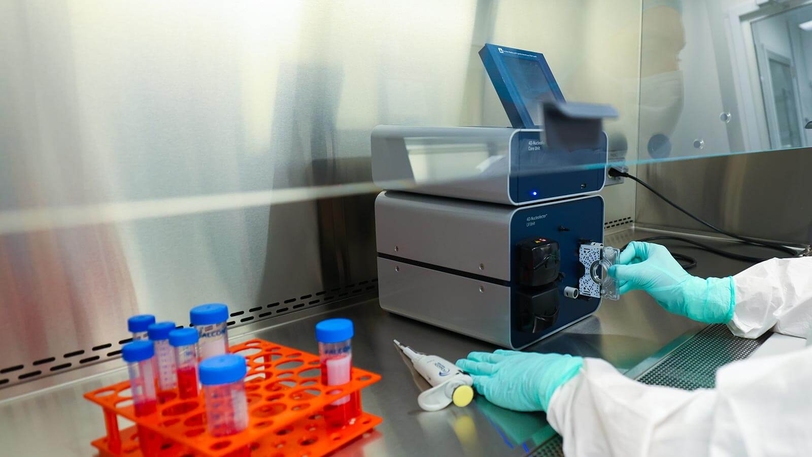 tech holding a vertical like disc and inserting into a machine for multiple myeloma trial