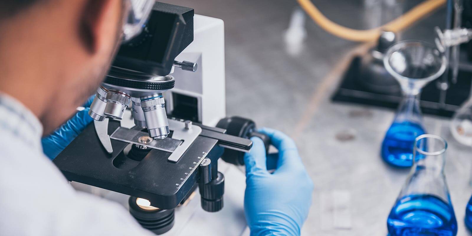 physician looking into microscope