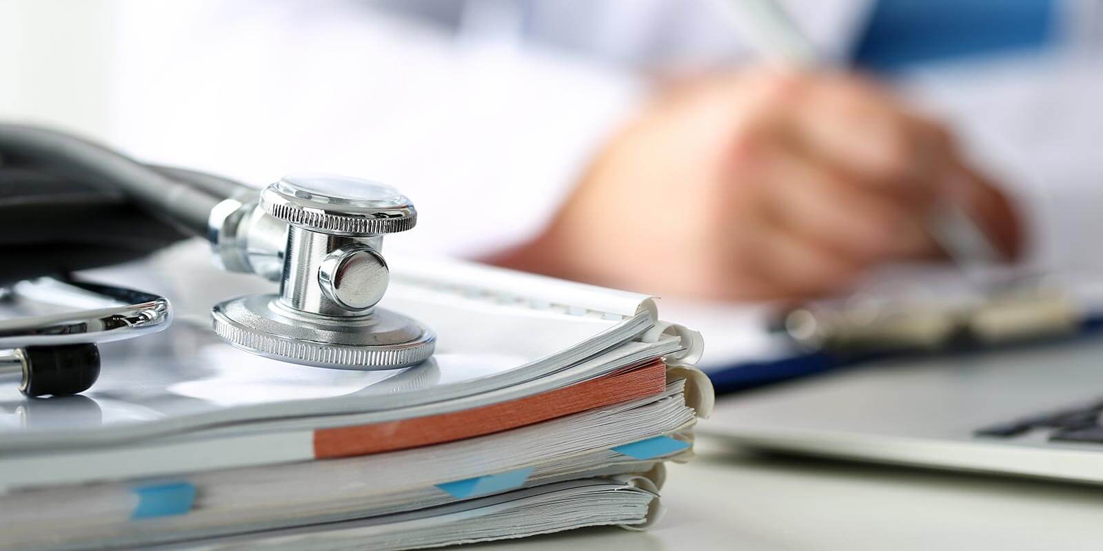 Stethoscope head lying on medical forms closeup