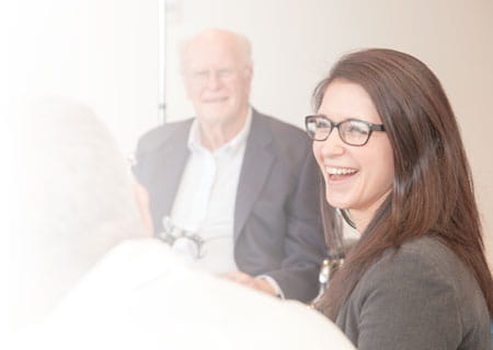 Young female patient laughing as her physician looks on