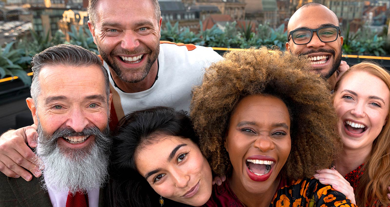 A diverse group of smiling people on a rooftop