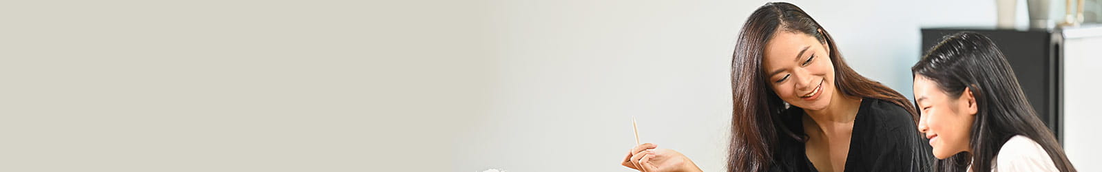 A woman guiding a young girl with her homework