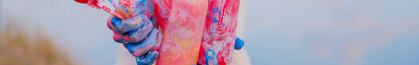 Girl in painted apron holding brushes and jar