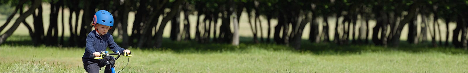 Child safely riding bike down sidewalk.