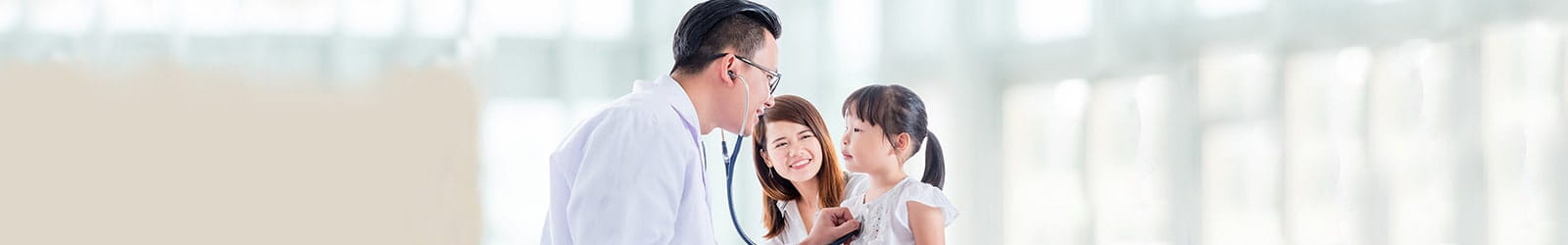 Doctor meeting with mother and child and listening to child's heartbeat.