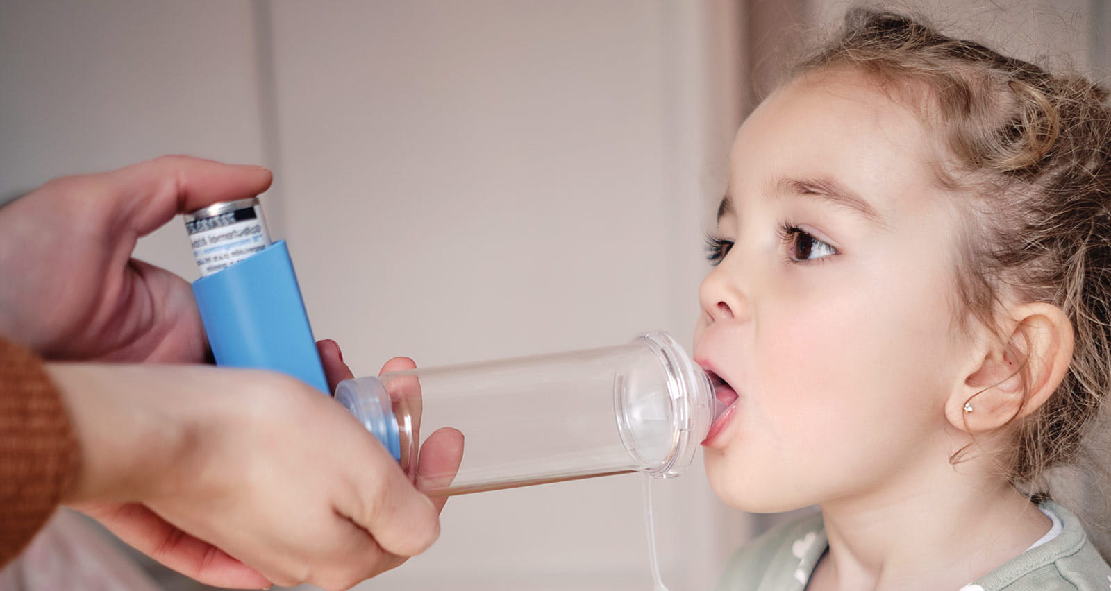 A girl using an asthma spacer