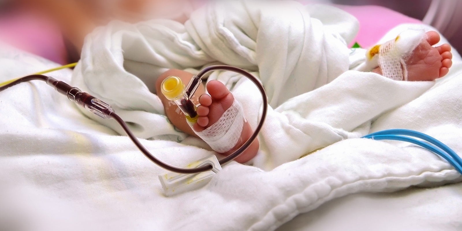 Baby laying in crib with IV.