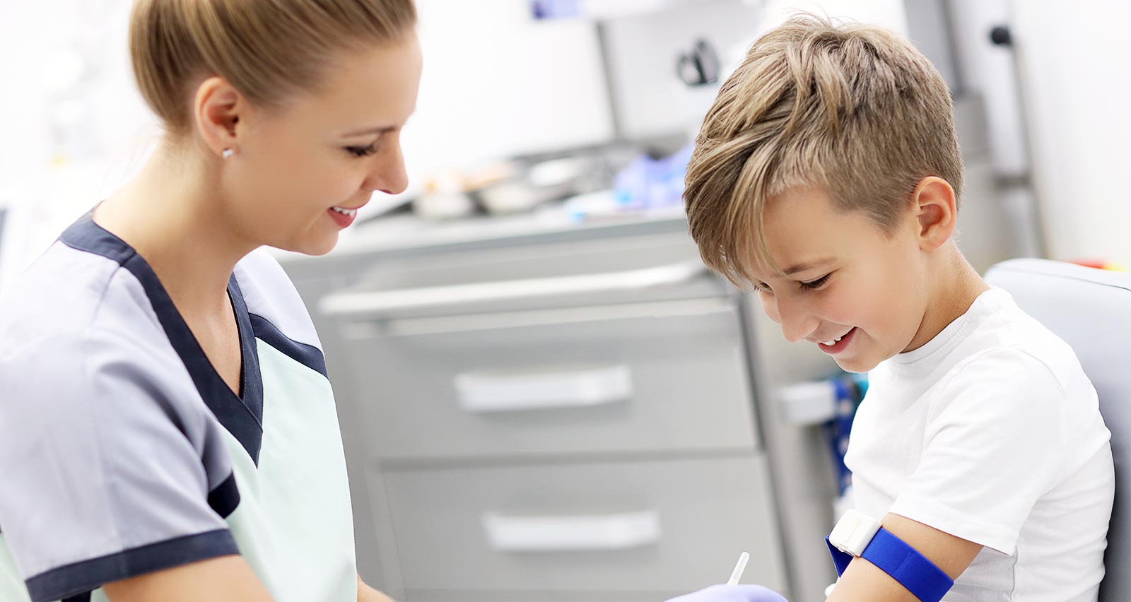 A brave little boy smiles while having his blood collected for tests