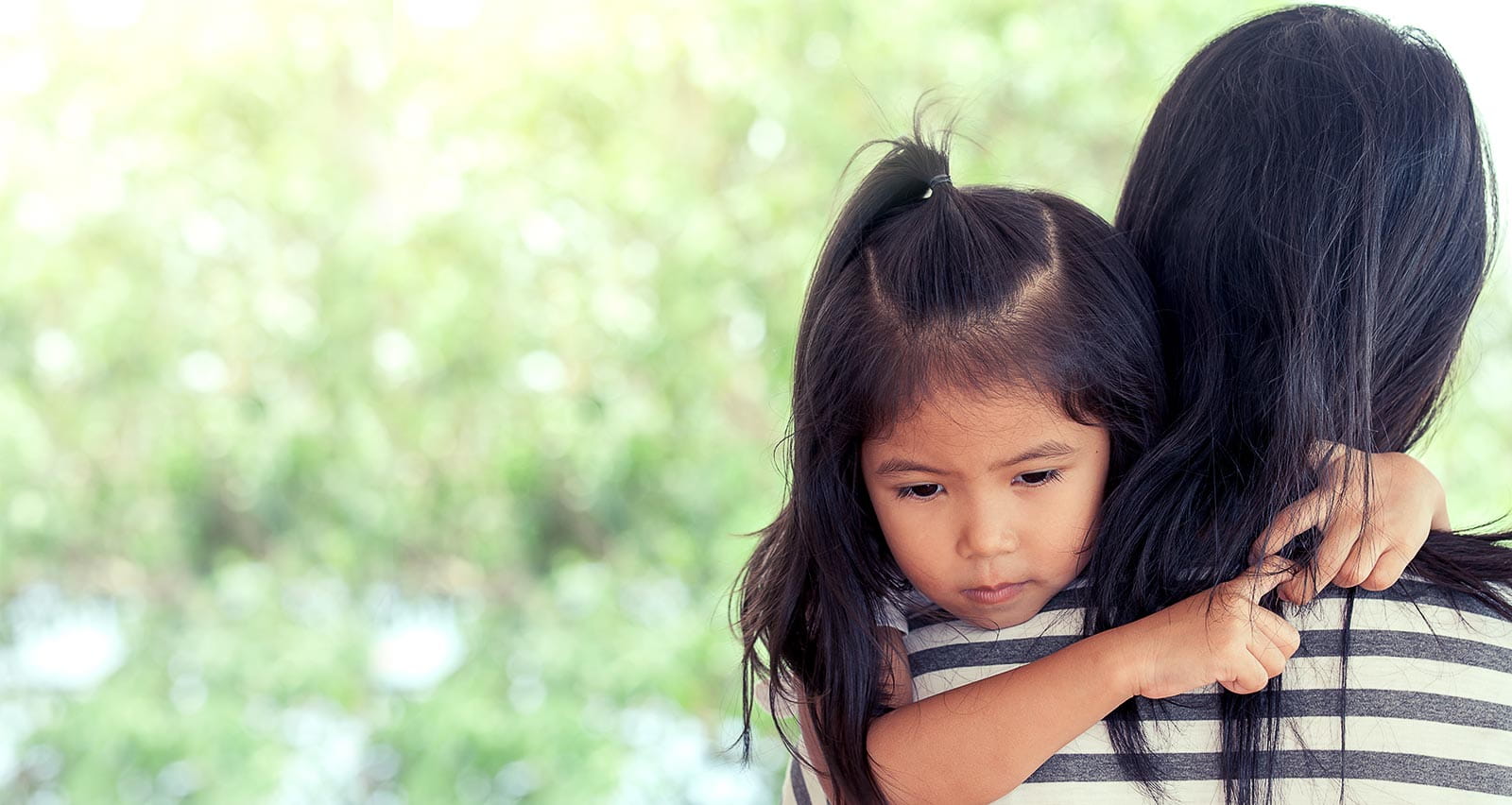 Mother and child cute little girl resting on her mother's shoulder