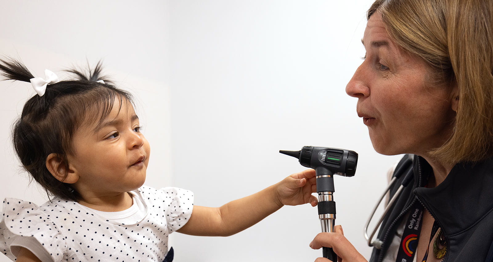 Eva Johnson, MD performs an ear exam on a young patient