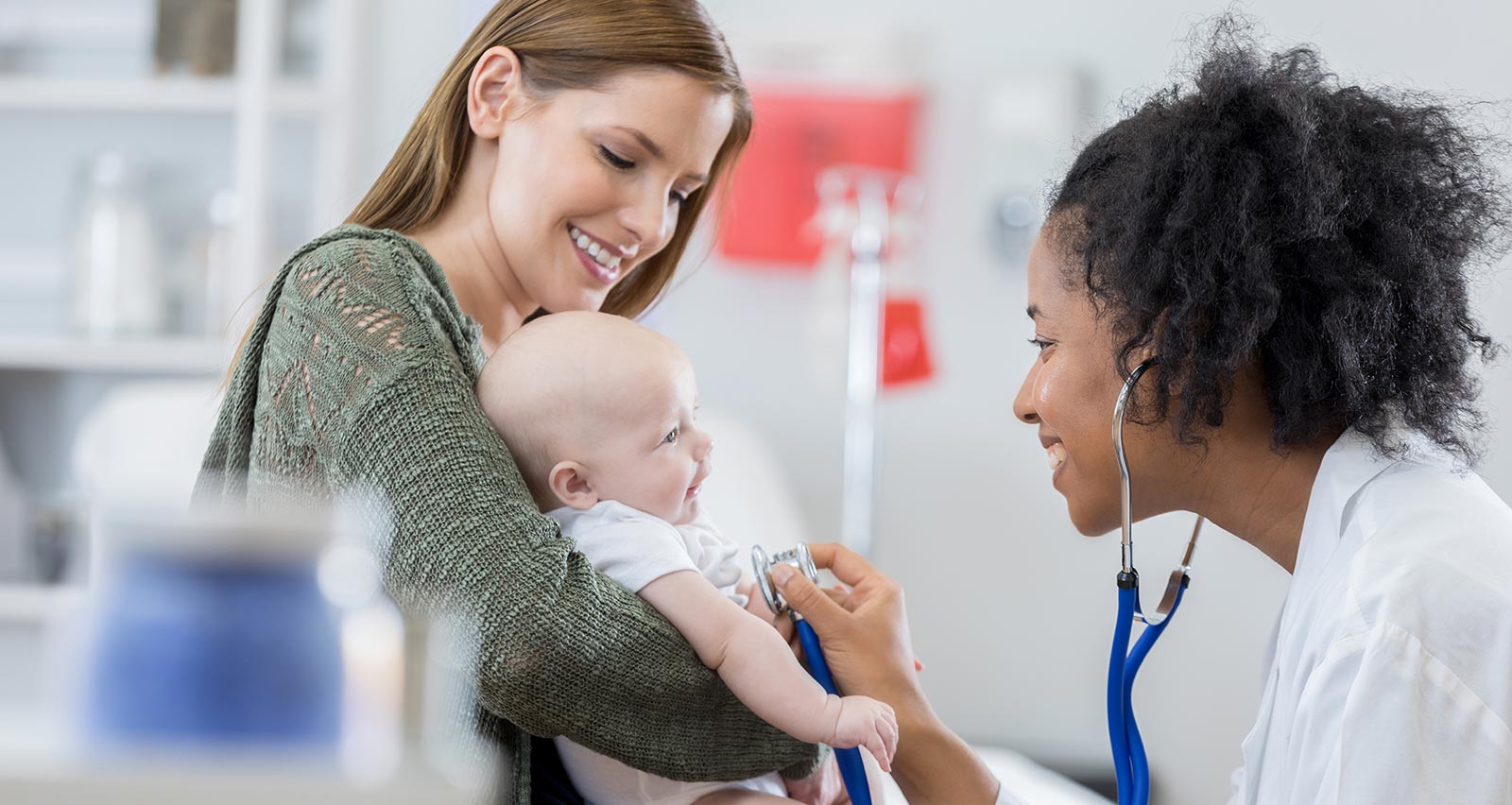 A confident female pediatrician listens to a baby’s heartbeat during an examination