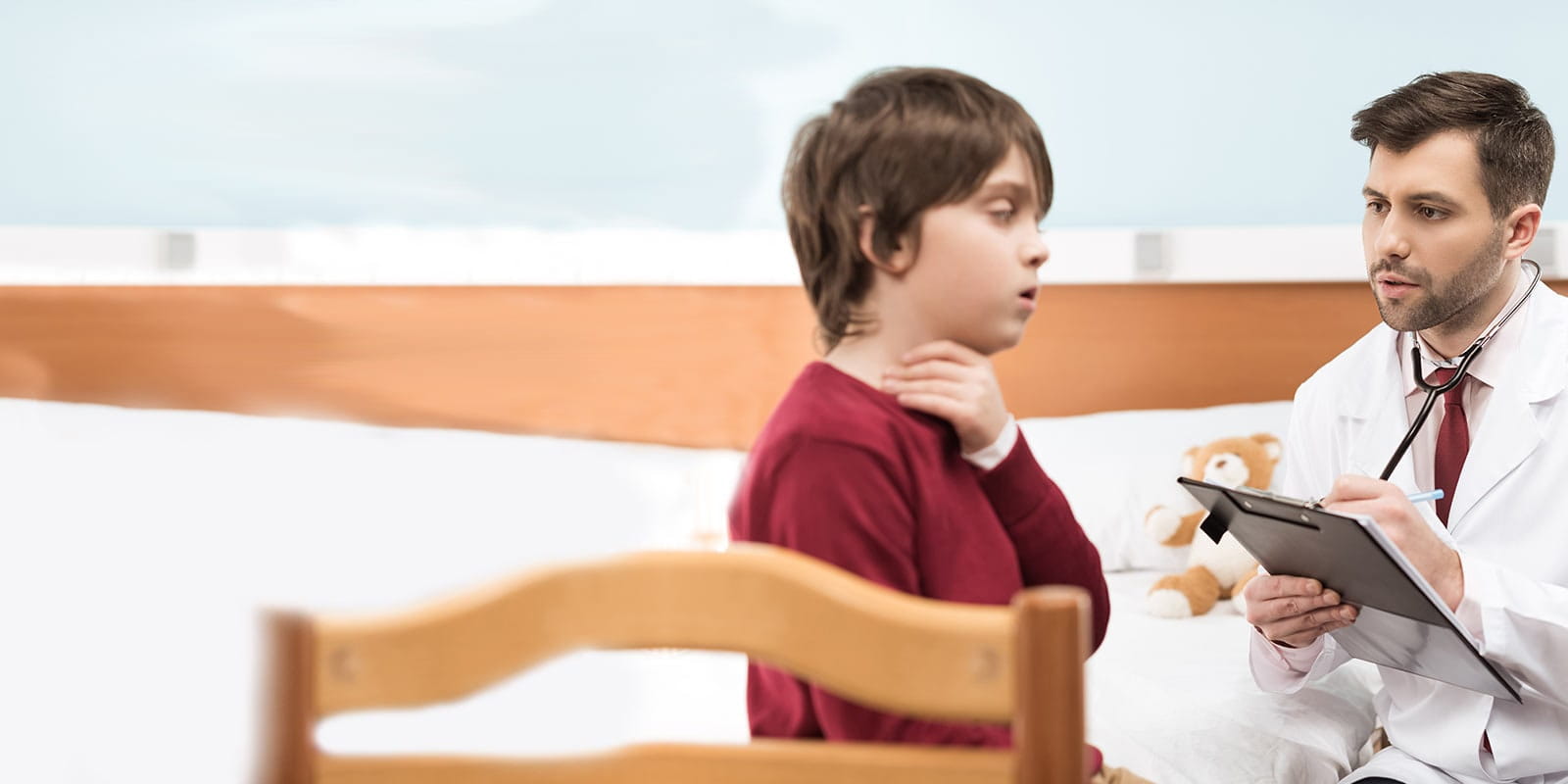 Boy describing his throat issues to his pediatrician.