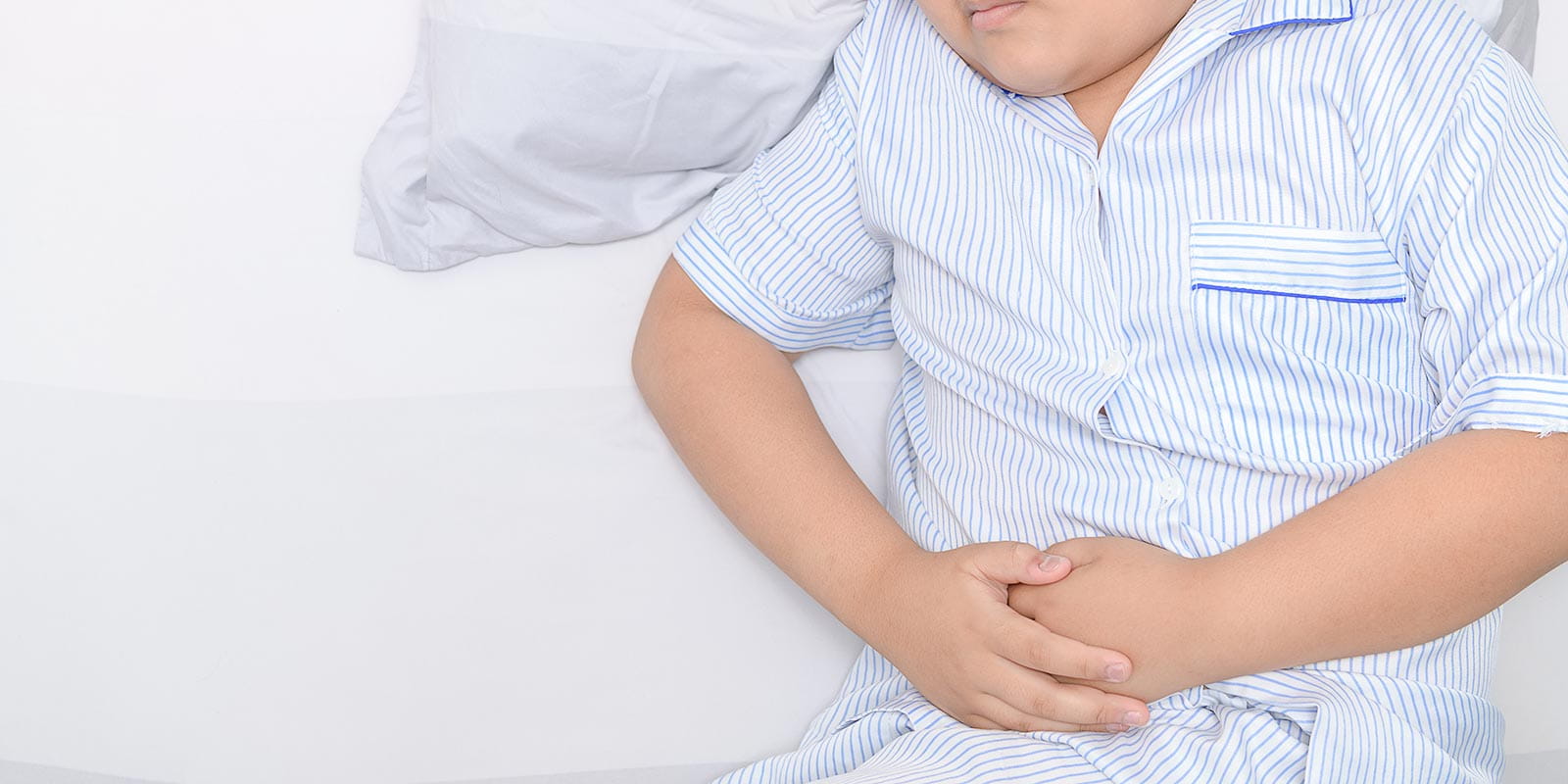 A young boy clutching his stomach