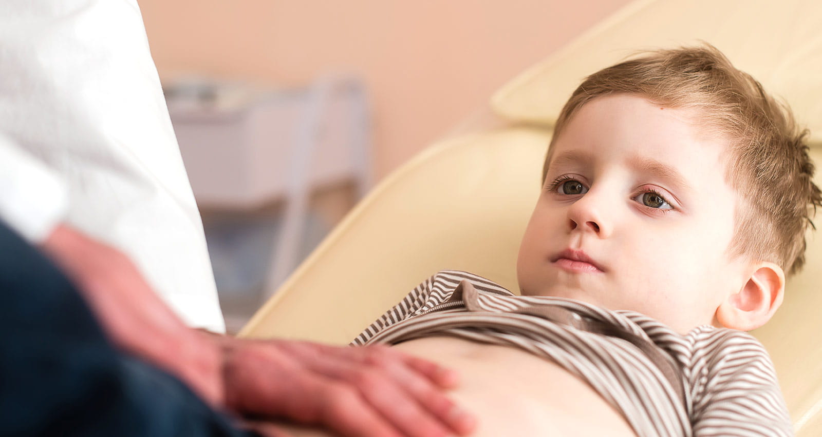 Pediatrician examines a child's stomach area