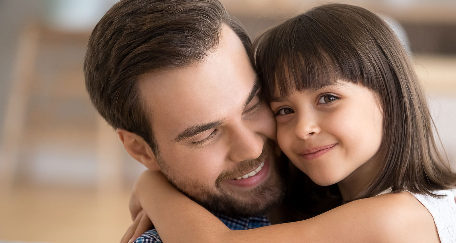A loving dad and daughter hug at home
