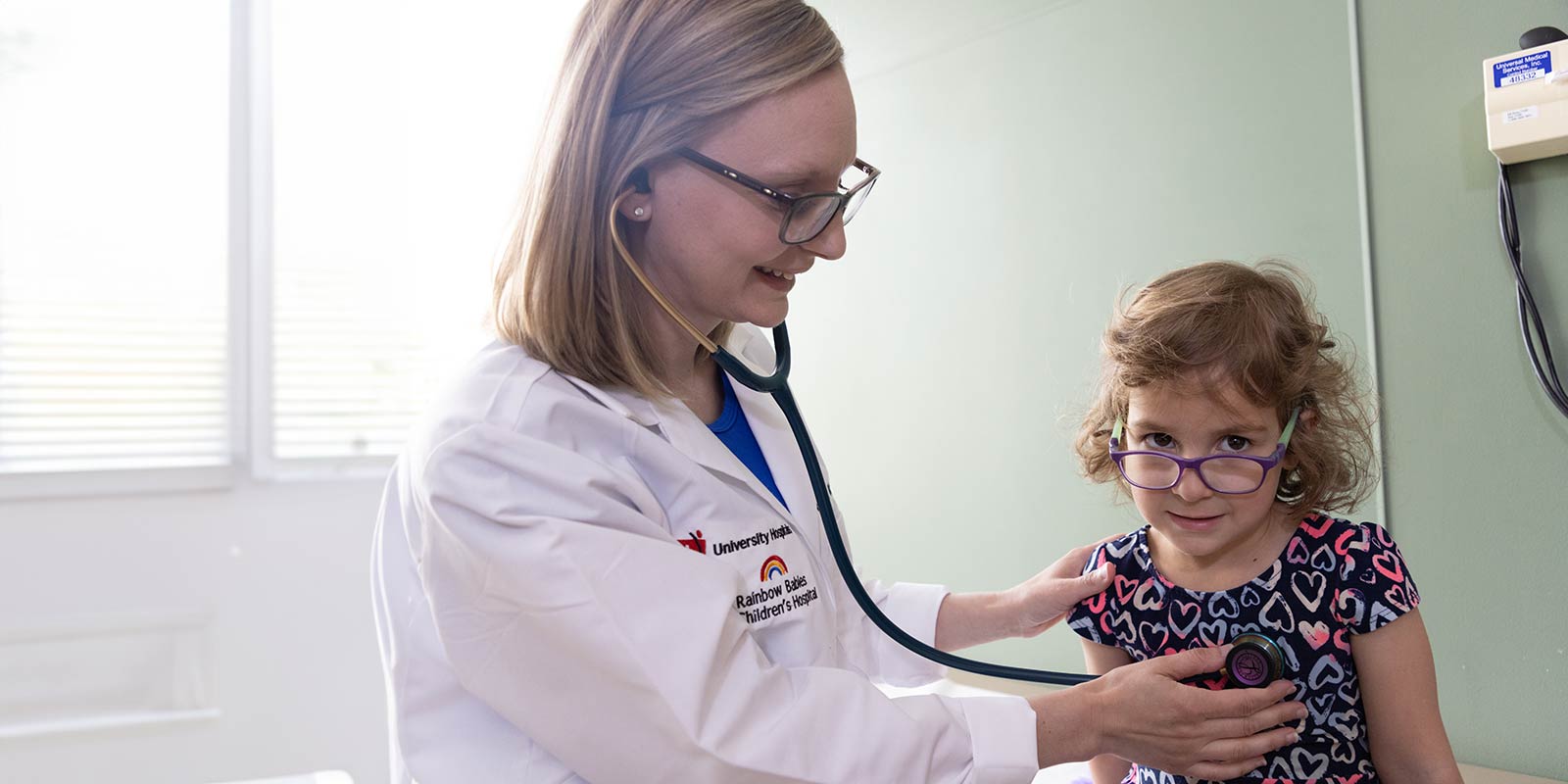 Doctor with young female patient in office.