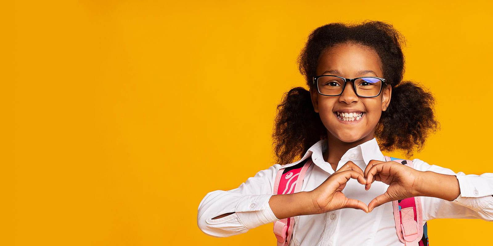 African American Schoolgirl Showing Heart Gesture With Hands