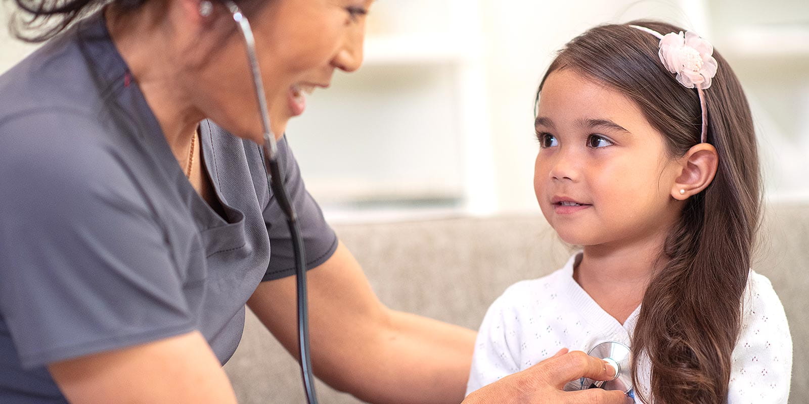 A young girl having her heart checked by a provider using a stethoscope