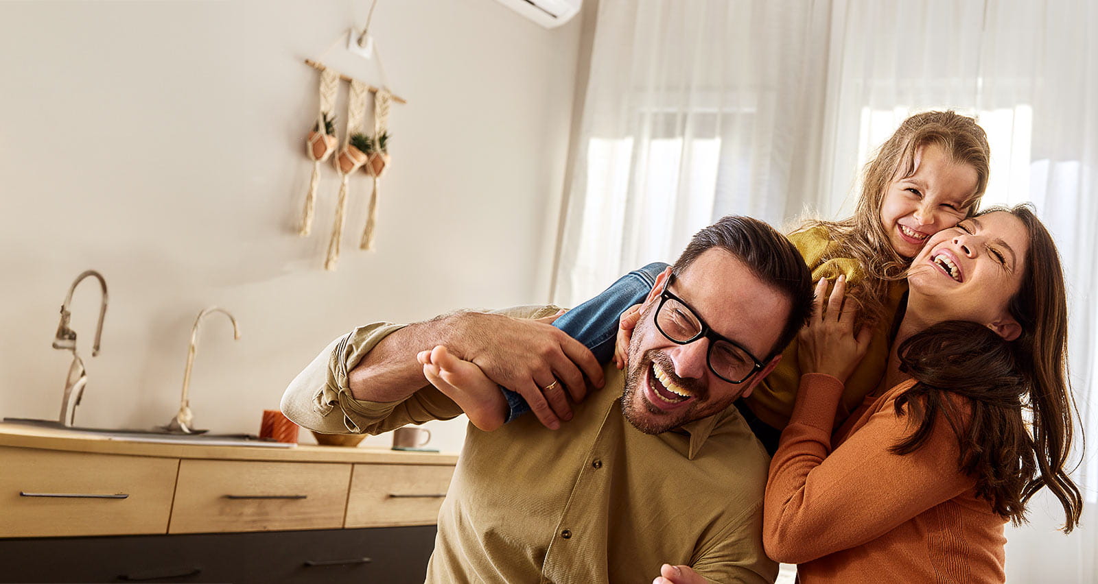 A cheerful young girl having fun with her parents at home