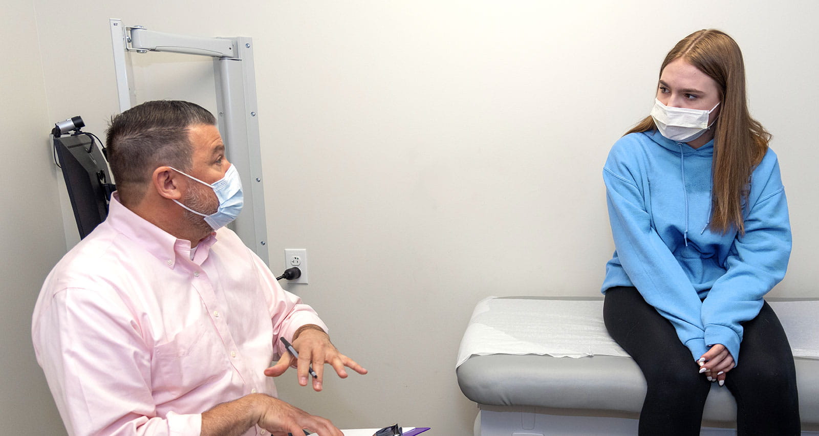 David Miller, MD, LAc consults with a young female patient