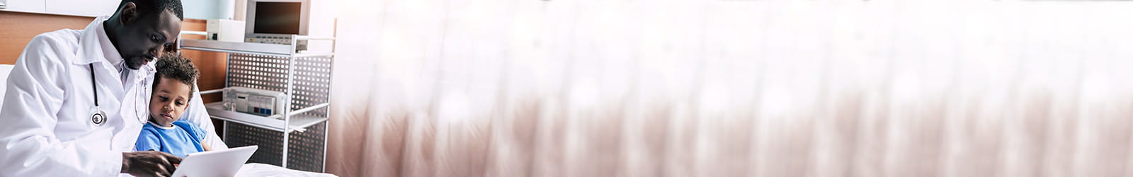 Doctor showing child medical tablet in patient room.