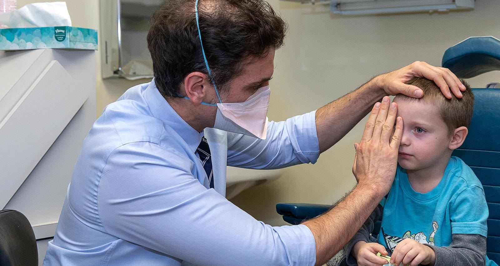 Maryo Kohen, MD performs an exam on his young patient