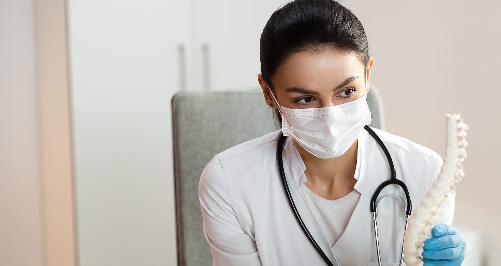A small girl with her mother listening attentively to pediatrician describing spine surgery
