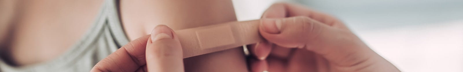 Doctor putting bandage on child's shoulder.