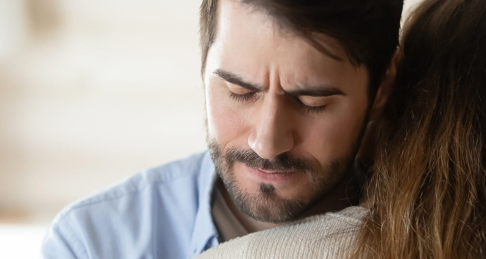 Compassionate millennial man hugging young suffering woman sharing her grief