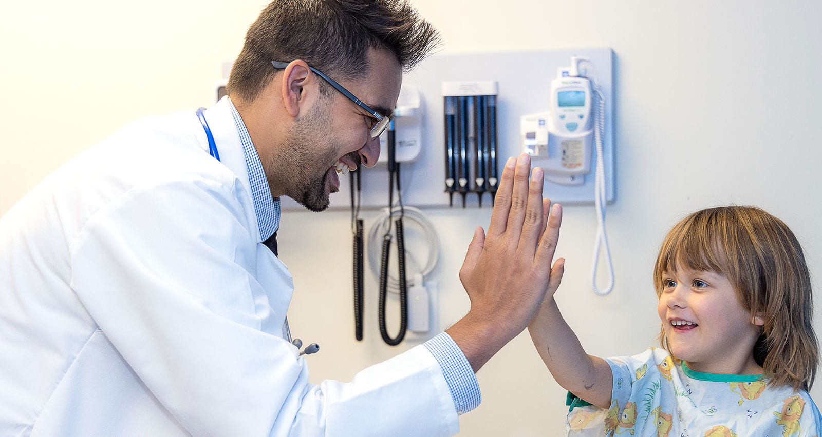 Omkar Phadke, MD high fives a young patient