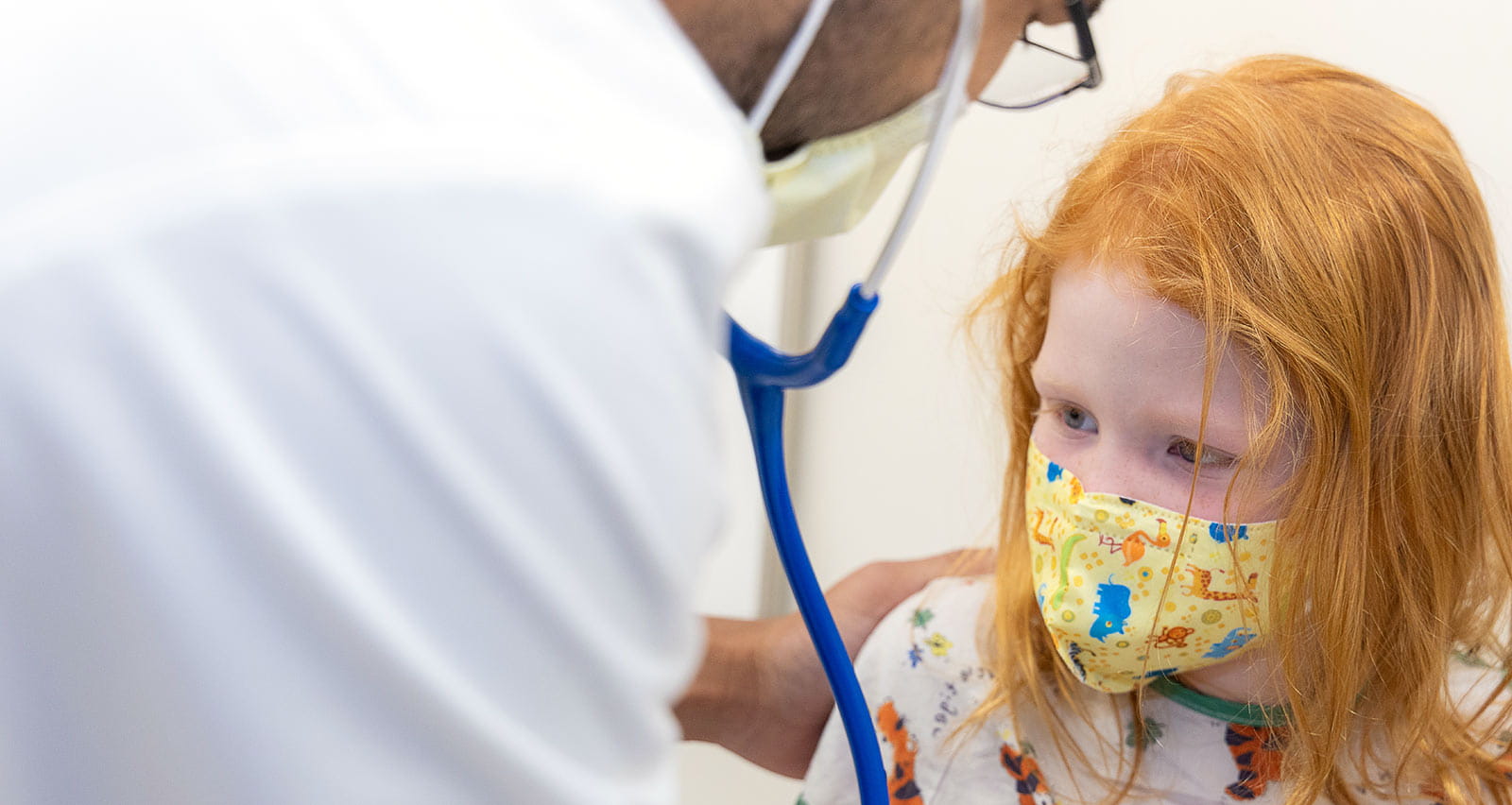 Omkar Phadke, MD examines a young female patient