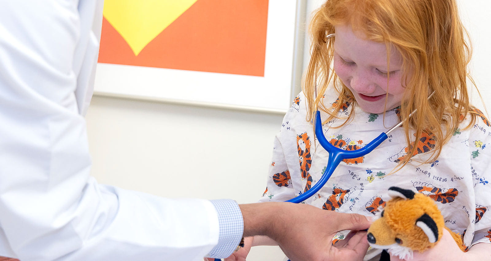 Omkar Phadke, MD examines a young female patient