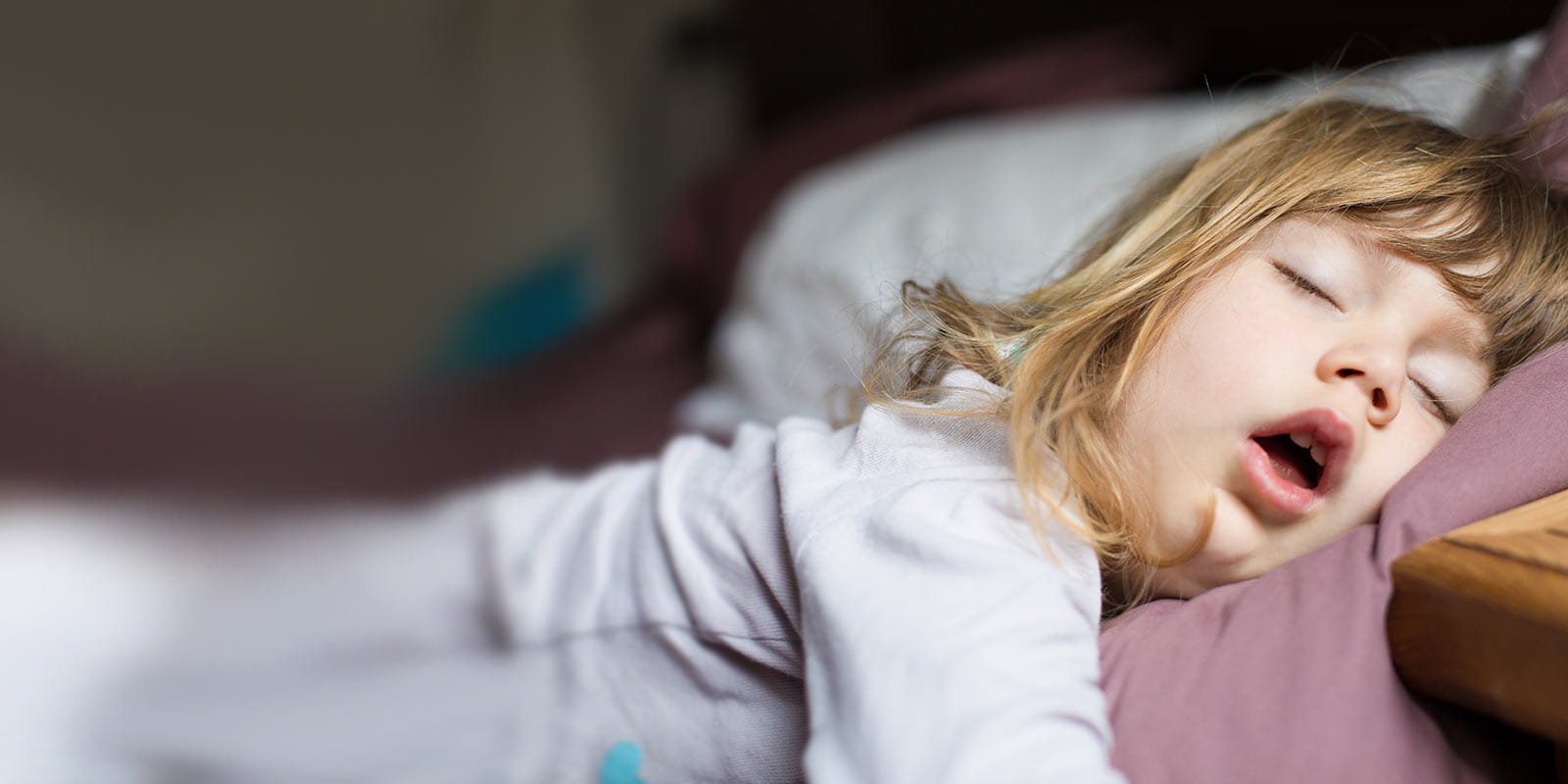 A little girl sleeping with her mouth open.