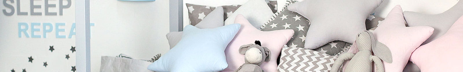 A child's bedroom with shaped pillows