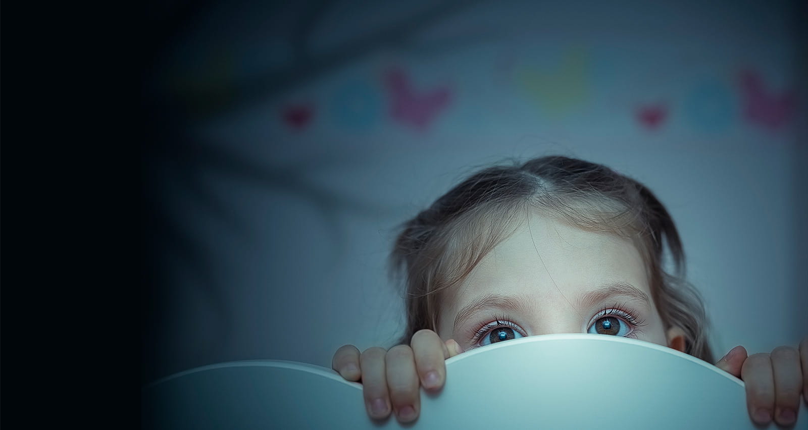 A sleepless little girl clutching at the foot of her bed
