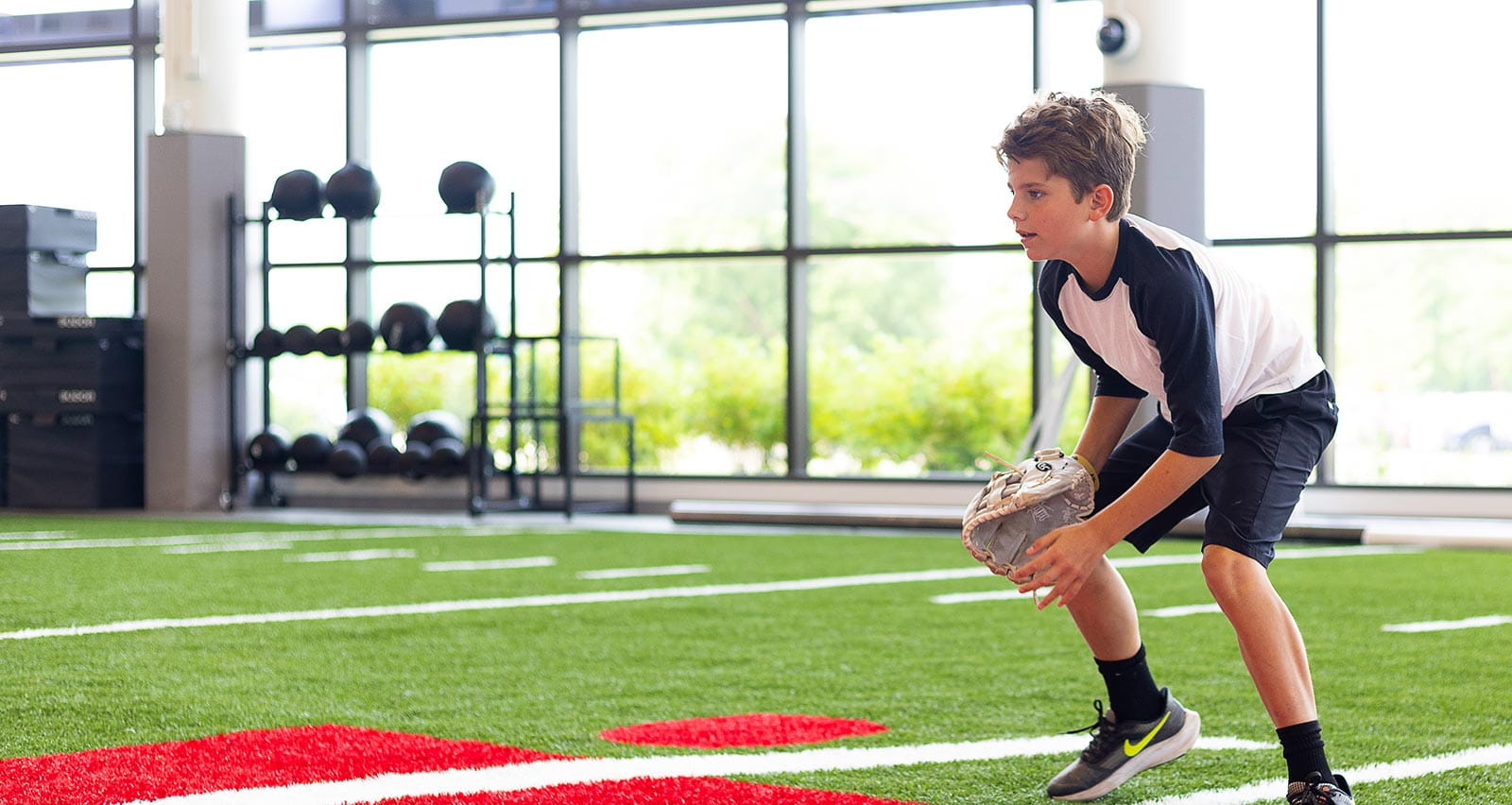 A young boy plays baseball on the UH Drusinsky Sports Medicine Institute indoor field