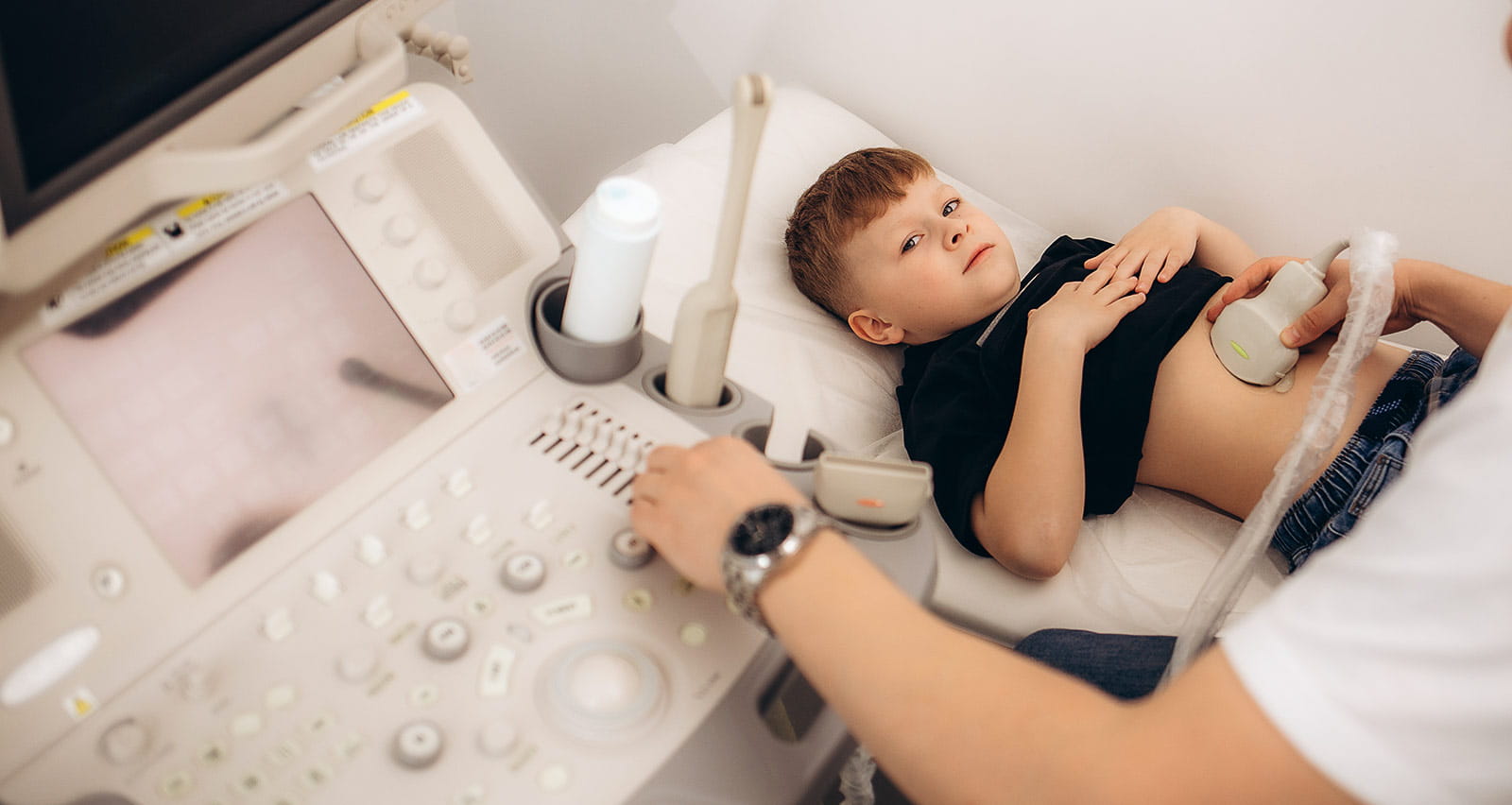 A doctor conducts a kidney ultrasound on his young patient